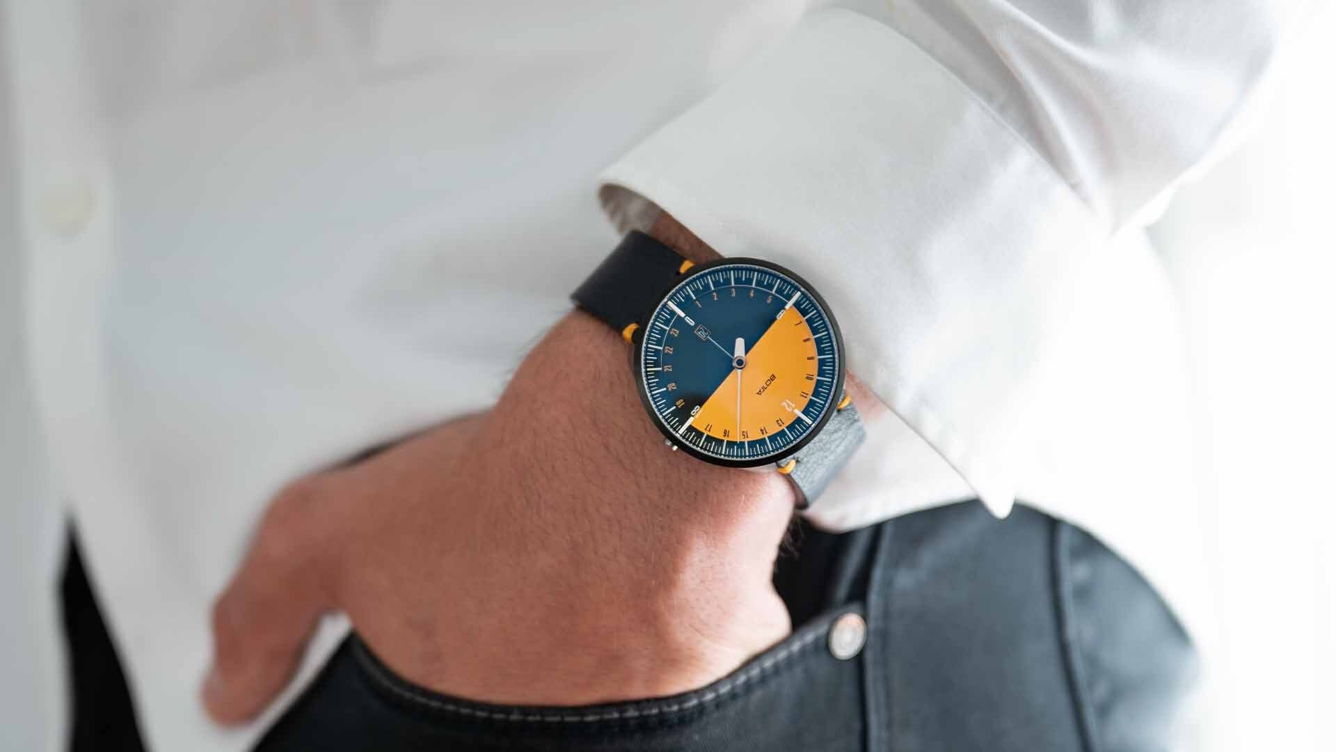 A man putting his hands into his jeans pocket, wearing a BOTTA Design Uno 24 Edition watch.