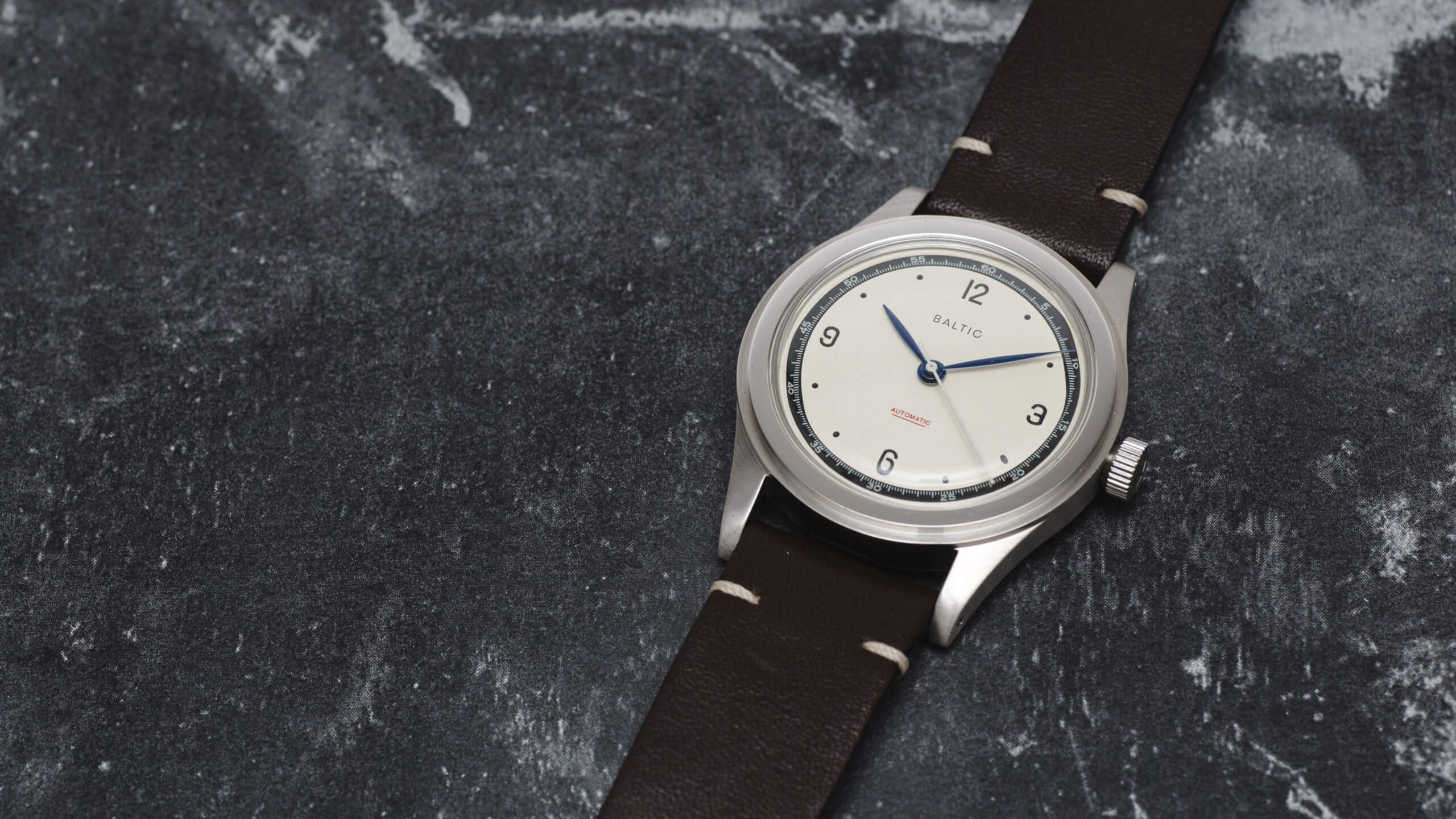 Baltic HMS 01 timepiece with a cream coloured dial and dark brown leather strap.