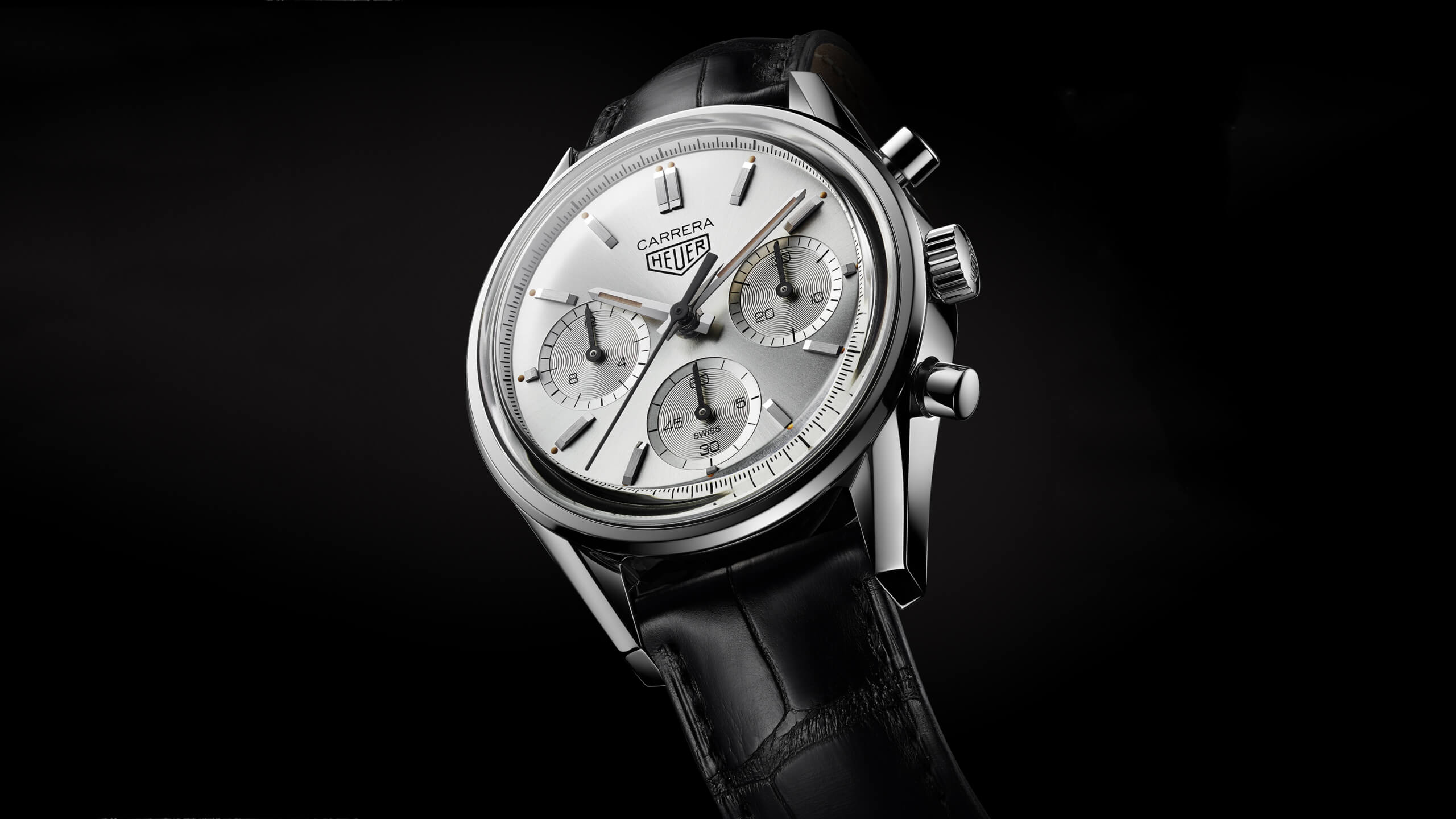 TAG Heuer Carrera timepiece. With a silver dial and a black leather strap.